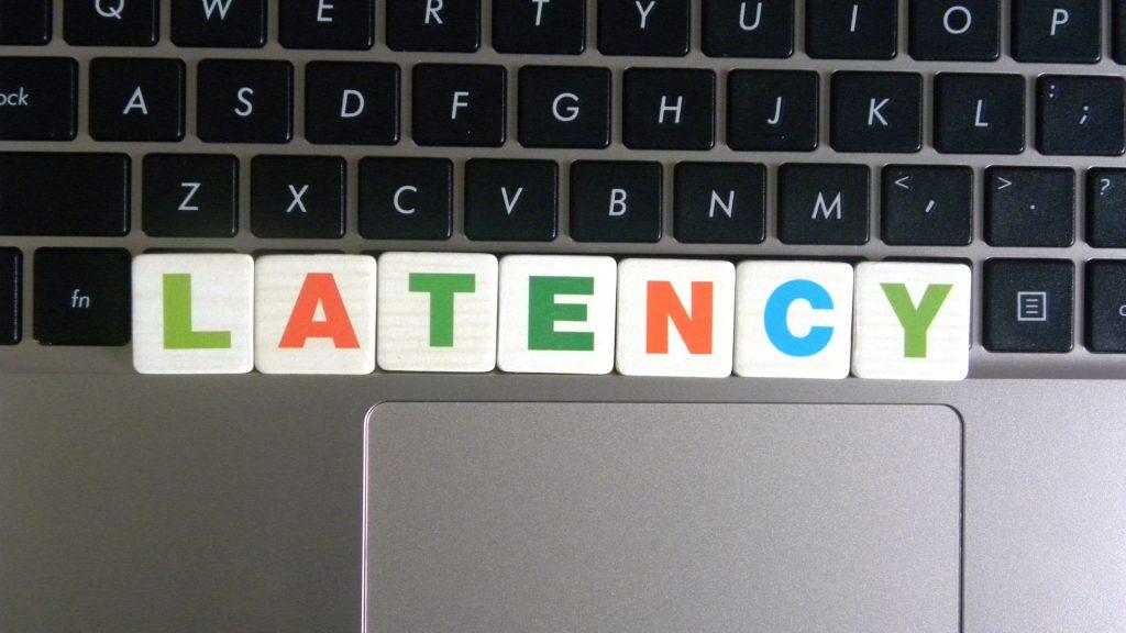 The word "Latency" spelled in tiles in front of a computer.